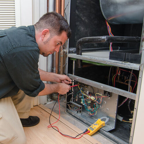 Heating company technician services a furnace.