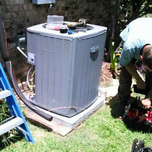 A Technician Works on an Air Conditioner.